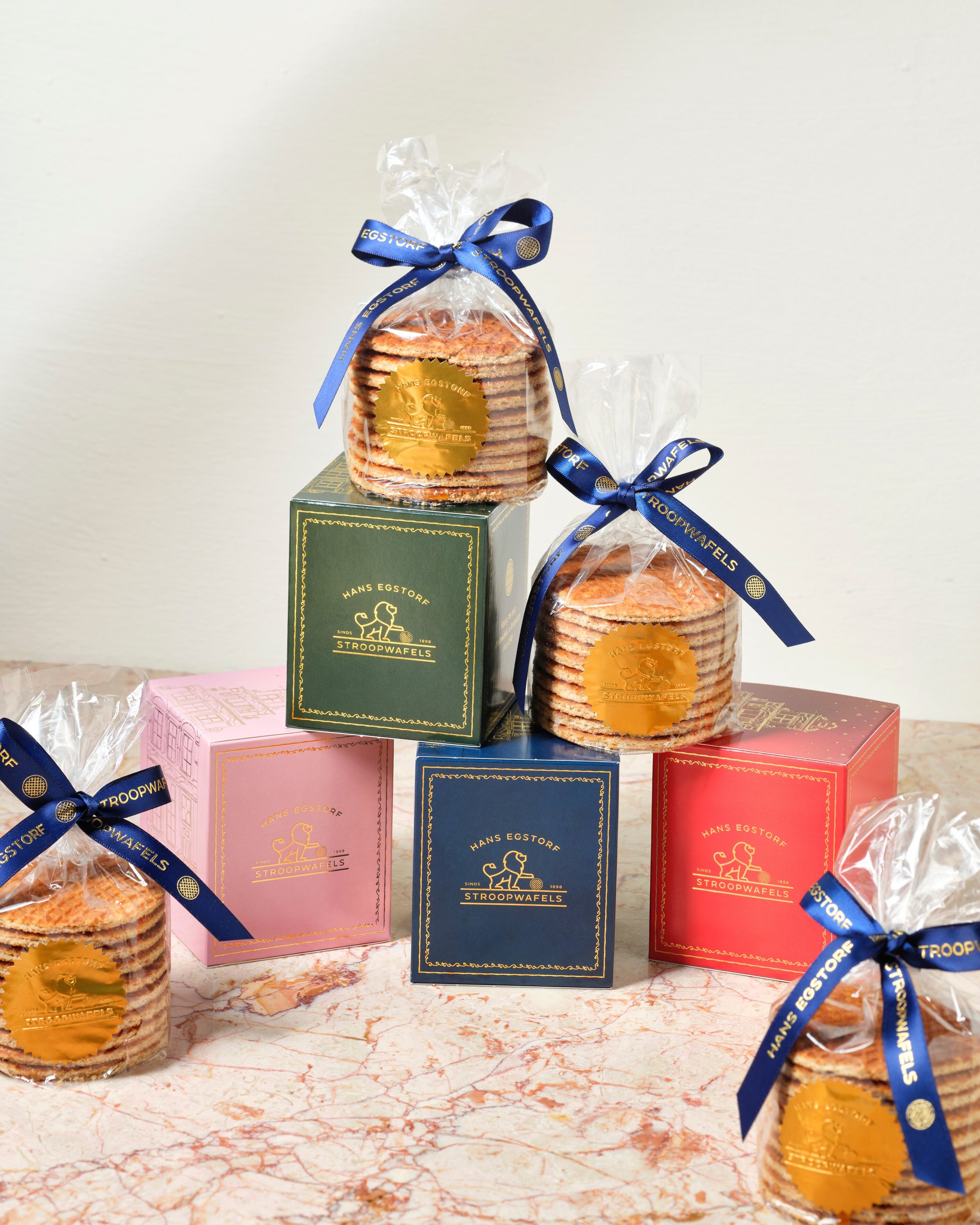 Stroopwafels in decorative boxes with blue ribbons on a marble surface